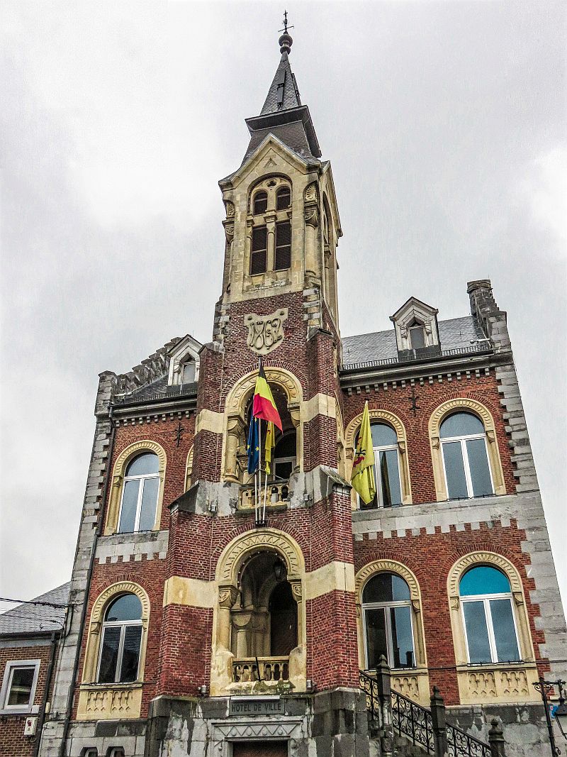 Beautiful building with the Belgian and EU flags on the facade. The town hall in Rochefort, Belgium, Wallonia, 