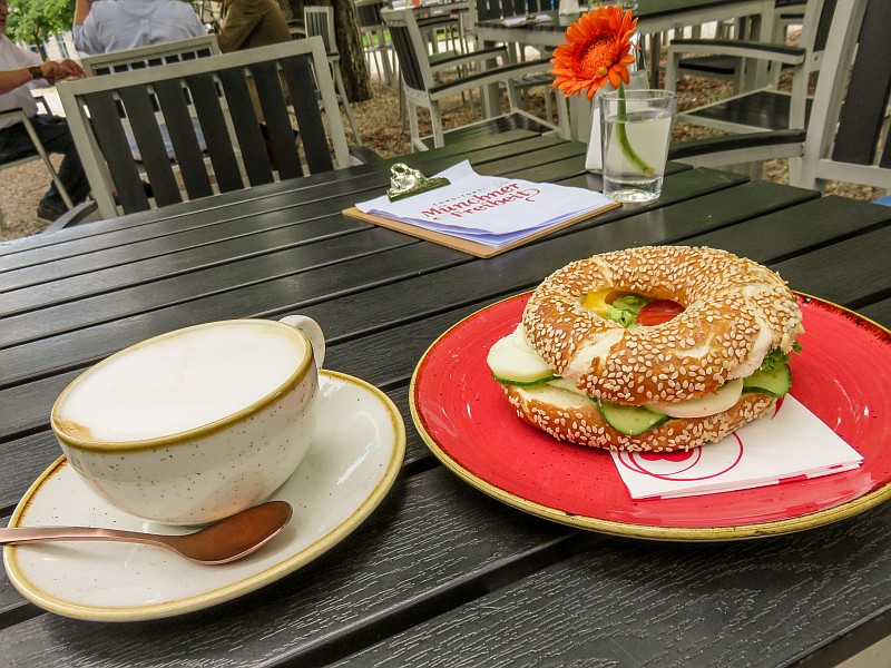 a cup of cappuccino and a bagel on a table, late lunch on the terrace of the cafe at the Pinakothek der Moderne