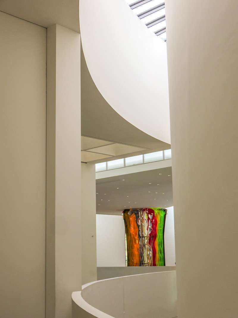 interior of a museum with modern architecture and winding rounded staircase, Pinakothek der Moderne in Munich Germany