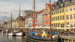 best European city breaks autumn, brightly painted houses and boats in a harbour, Nyhaven in Copenhagen, Denmark
