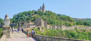 a road leading to a medieval fortress with a church on the top of the hill; Tsarevets Fortress in Veliko Tarnovo