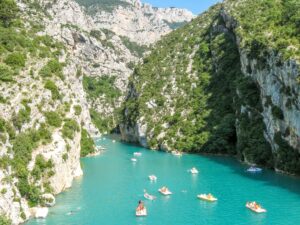 Peddle boats on a lake entering a a narrow gorge; Gorges du Verdon Travel Guide