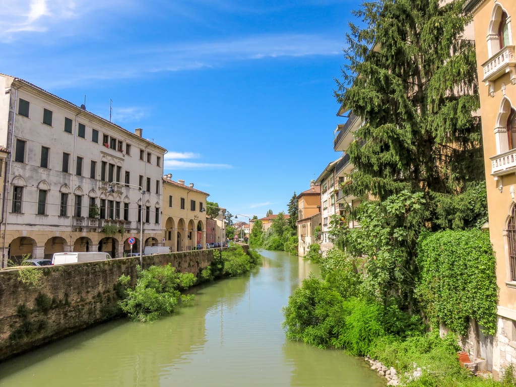 a river in a city lined up with colorful buildings on the shores; Padua and Bacchiglione River