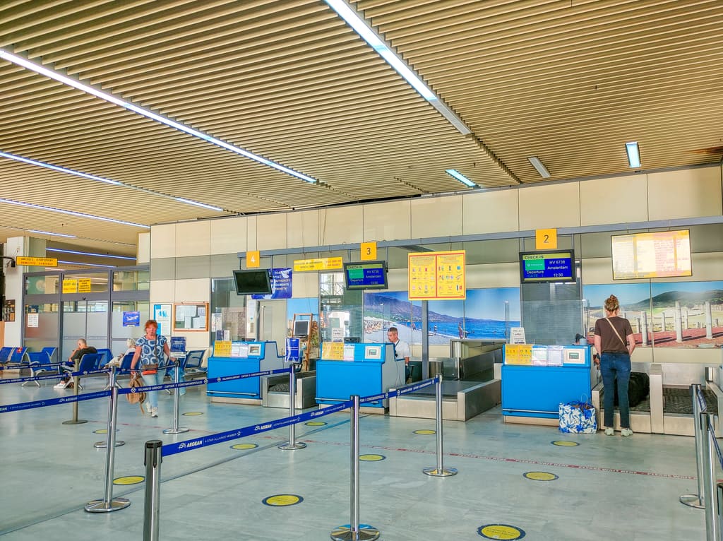 The interior of an airport with some desks and information boards with flights. The Kalamata International Airport in Greece