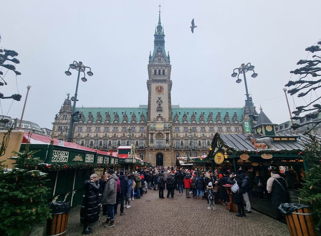 Christmas market in Germany with stalls and lots of people walking around and looking at the stalls. Hamburg Christmas Market