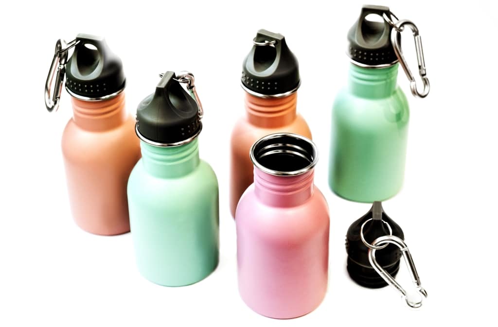 Five small reusable metal water bottles in pink, blue, and green are shown. Four bottles have black lids with carabiner clips attached, while one bottle has its lid removed and placed beside it. The background is white.